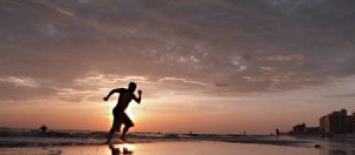 Deportista corriendo en la arena