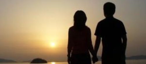 A couple holding hand and watching sunset