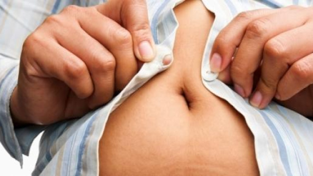 Un obeso tenta di abbottonarsi la camicia