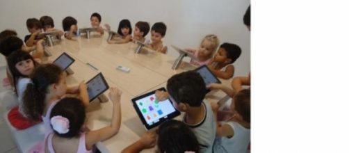 Crian&ccedil;as em sala de aula usando tablet