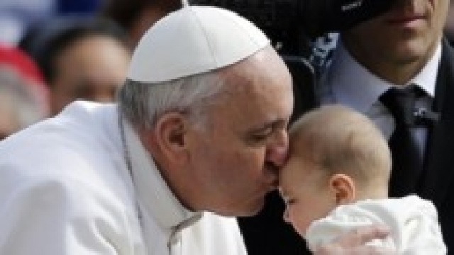 Papa Francesco bacia un bambino