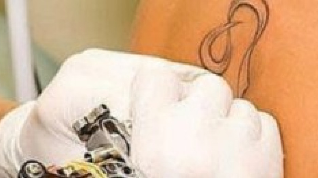 Un tatuatore mentre fa un tatuaggio 