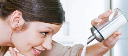 Chica poni&eacute;ndose az&uacute;car en el caf&eacute;