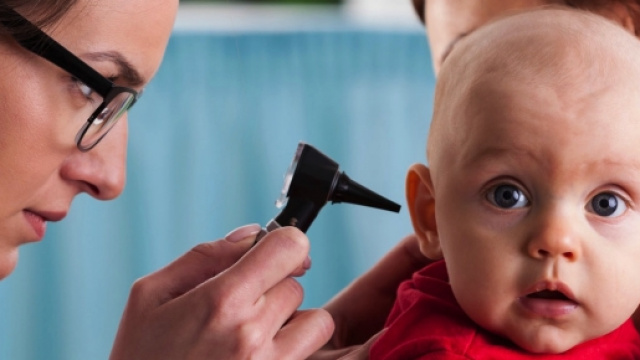 Un medico visita un bimbo colpito da otite