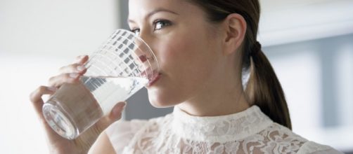 Chica bebiendo un vaso de agua
