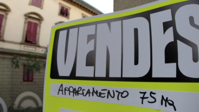 Un cartello "vendesi" in un centro cittadino