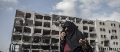 Edificio y mujer desolados por los ataques
