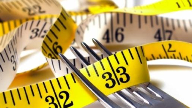 Forchetta e metro, due simboli della dieta