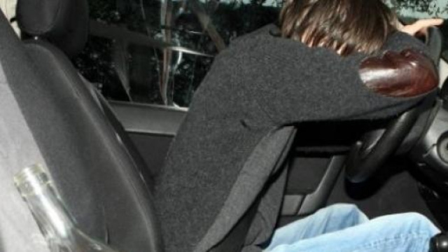 Uomo ubriaco al volante con bottiglia