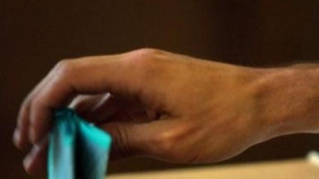 Un elettore depone la scheda nell'urna