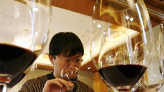 Cinese degusta un bicchiere di vino rosso