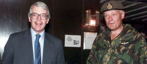 John Sewel tomando una cerveza junto a un soldado