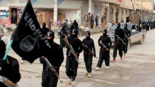 Miliziani dell'Isis con bandiera
