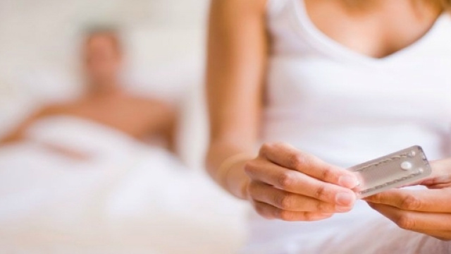 Immagine simbolica di una donna che si prepara ad assumere una pillola anticocenzionale