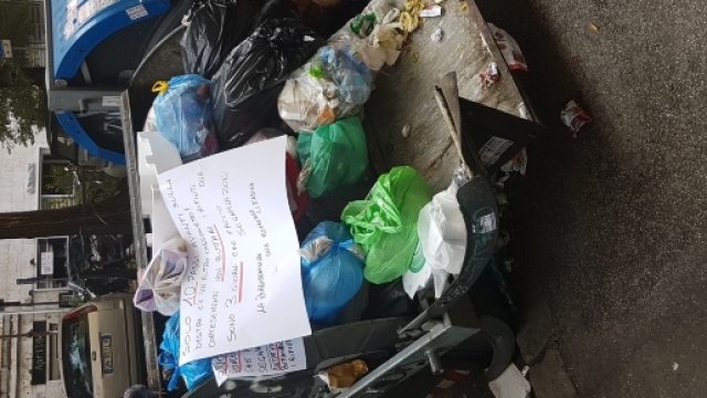 Il cassonetto di Viale Ippocrate con l'appello lanciato dalla negoziante