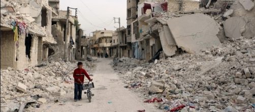 Ni&ntilde;o sirio camina en medio de un Aleppo en ruinas