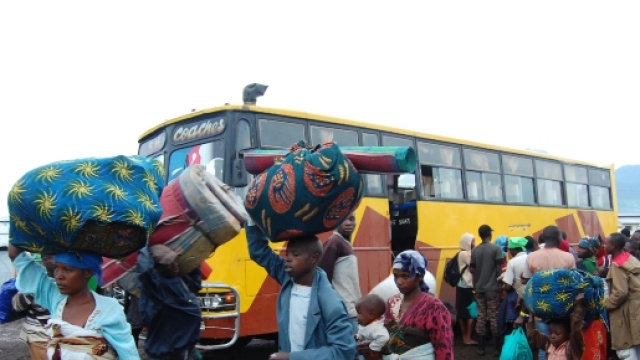 Migranti in attesa di salire su un bus