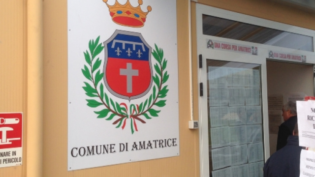 L'ingresso del prefabbricato sede del Comune di Amatrice: sulla porta l'esito delle perizie di agibilit&agrave; delle abitazioni.
