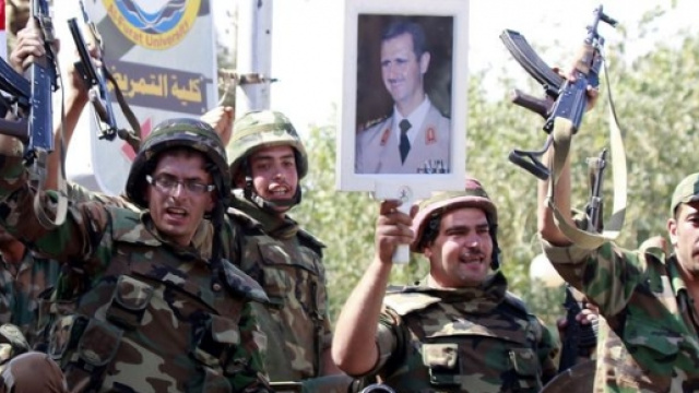 Militari siriani espongono l'immagine di Assad