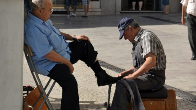 Un lustrascarpe mentre &egrave; intento nel suo lavoro