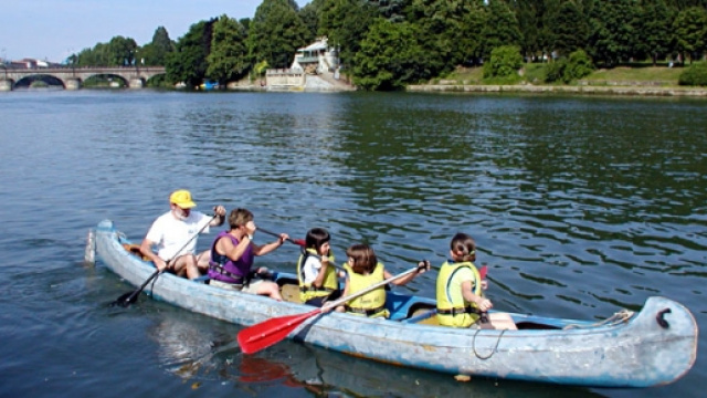 Canottieri sul Po con la collina sullo sfondo