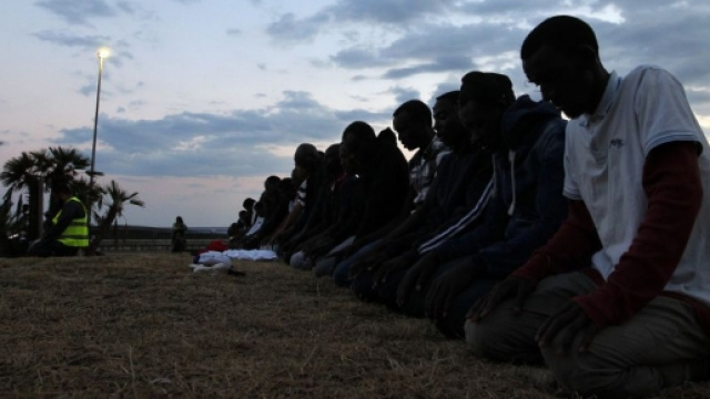 Musulmani improvvisano preghiera sulla spiaggia all'alba.