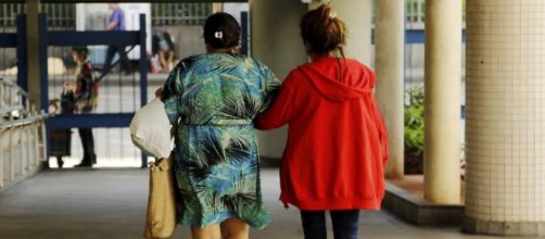 Menor que foi v&iacute;tima de estupro coletivo deixa o Hospital Souza Aguiar, acompanhada da m&atilde;e (Foto: Gabriel de Paiva/Ag. O Globo)