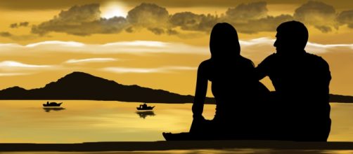 Pareja viendo el atardecer en el mar