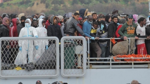 Operazioni di sbarco per un folto gruppo di migranti in un porto italiano