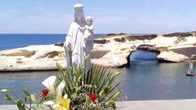 La statua delle "Vergine col bambino" e sullo sfondo S'Archittu.