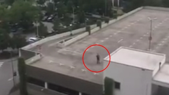 L'assalitore ripreso da un balcone che si affaccia sul parcheggio del centro commerciale