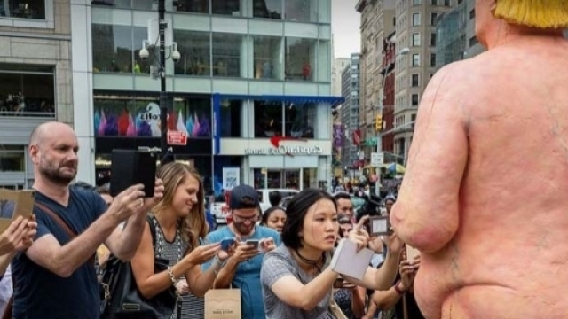 Passanti incuriositi dalla statua del candidato repubblicano Donald Trump