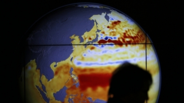 una donna passa davanti ad un mappamondo esposto alla conferenza di Parigi del 2015, l'internazionale