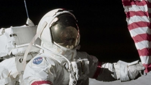 Eugene Cernan l'ultimo uomo sulla Luna tocca la bandiera americana nel 1972 nella regione lunare di Taurus Littrows
