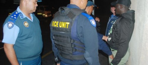 A Nigerian national, right, caught pimping underage South African girls. On left is vice squad deputy chief Nathan Lategouri (picture by author).