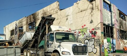 A truck loads debris from the gutted Ghost Ship warehouse in Oakland, Calif., where 36 died in a 2016 fire. (Photo: Jim Heaphy/Wikimedia Commons)