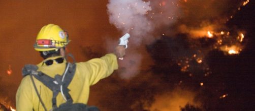 A firefighter shoots a flare to set back burn while battling the California wildfires.[image credit;Andrea Booher/wikimedia commons]