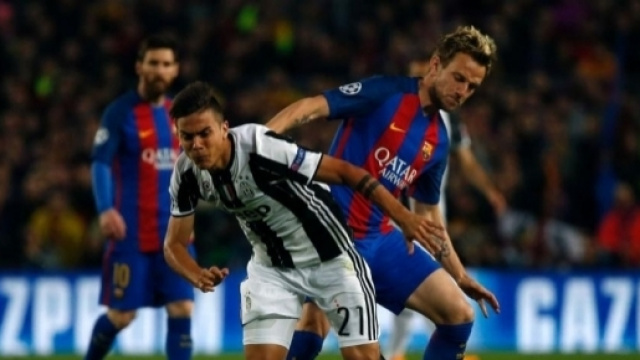 Paulo Dybala, 24 anni, contende il pallone a Ivan Rakitic, 29 anni, sotto lo sguardo di Leo Messi