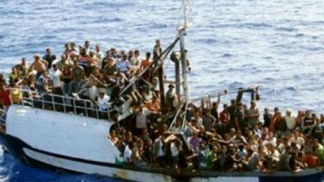 Un barcone colmo di immigrati pronti a sbarcare
