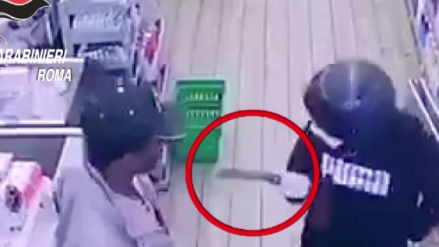 Il rapinatore minaccia l'extracomunitario con una mannaia, ma viene neutralizzato e fatto arrestare dall'anonimo eroe.