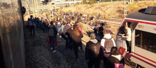 Usuarios de Cercan&iacute;as este lunes caminando por las v&iacute;as de Atocha tras estar encerrados mas de 25 minutos por una incidencia.