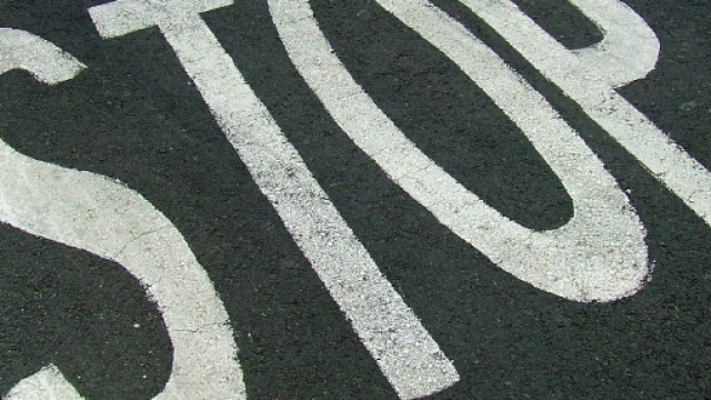 Il segnale di stop sull'asfalto stradale