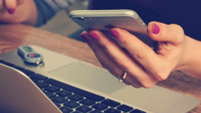 Una lavoratrice con in mano un telefono