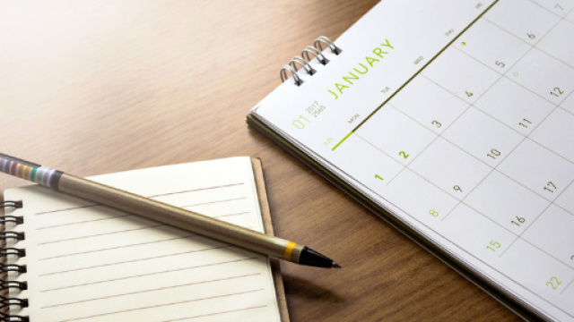 Un bloc notes, una penna ed un calendario