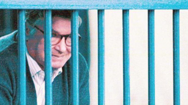 Tot&ograve; Riina deitro le sbarre durante un processo.