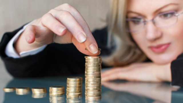 Una lavoratrice mette in fila monete da un euro