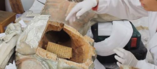 A restoration worker with the Jesus Crucified statue [Image credit: Da Vinci Restauro/YouTube]