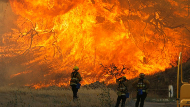 Alcuni pompieri che cercano di contenere le fiamme