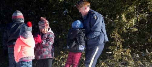 RCMP assisting family from Sudan crossing US - Canada Border from Champlain NY (credit Reuters Christine Muschi)
