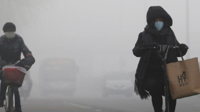 Pedoni con maschere antigas. Allarme rosso in Cina per alti livelli di inquinamento (foto-reuters)